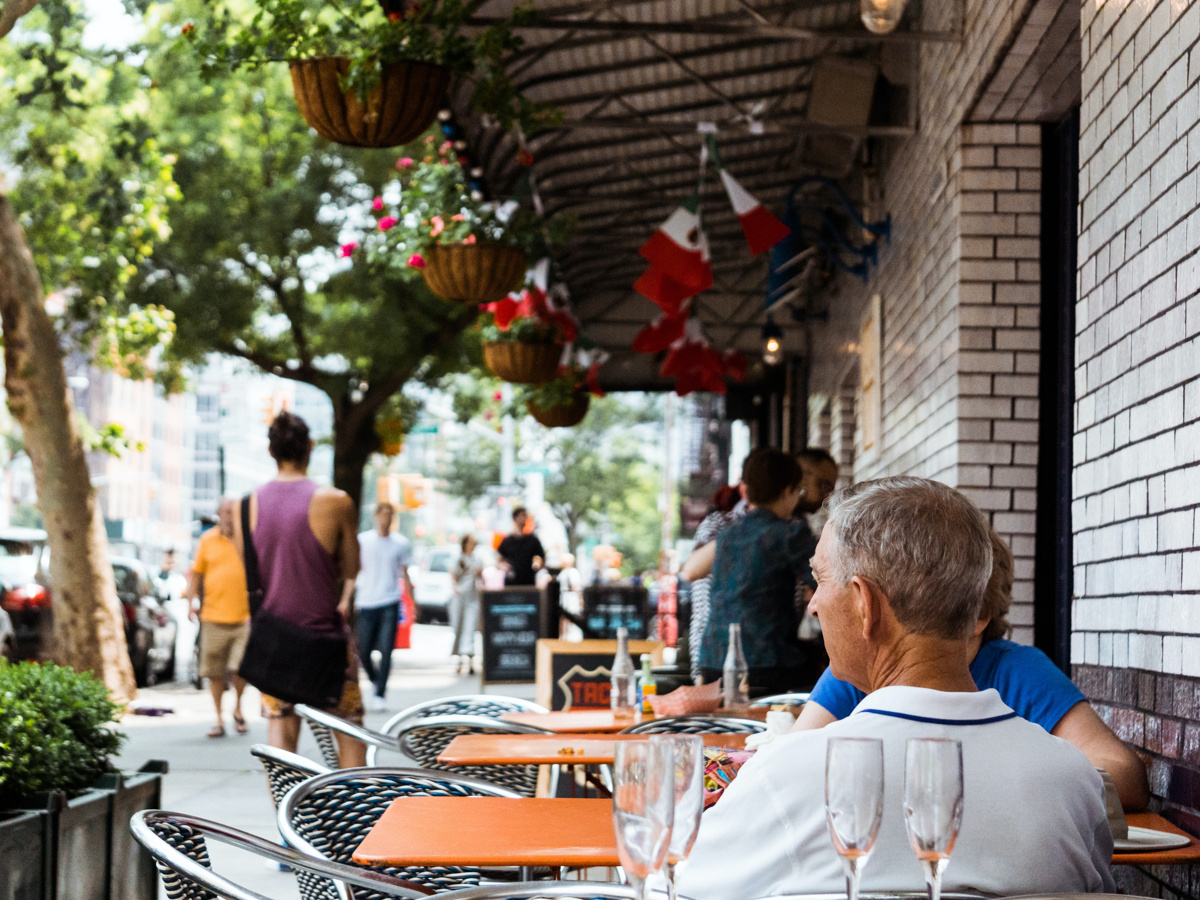 Two people sitting outside a restaurant in NYC.