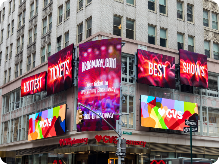 A view of Broadway.com office building in New York City with advertisements on the facade